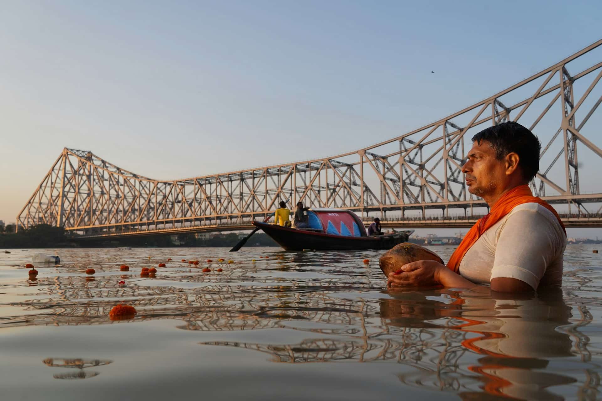 Man Praying to the Sun God in Water with Coconut During Chhath Festival